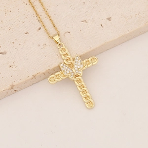 Detailed view of an 18K gold plated cross pendant with a zircon butterfly on a stone base