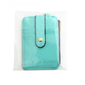 Close-up of a mint green leather card holder with vertical zip pocket and snap closure