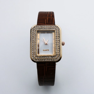 Close-up of square gold watch face with double crystal borders and brown leather strap
