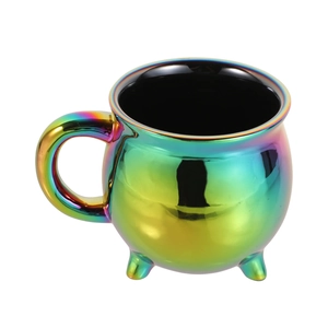 Close-up of rainbow iridescent cauldron mug with three legs and handle on white background