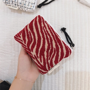 Macro view of red and white zebra pattern fabric mini pouch with a simple wish label