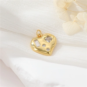 Close-up of golden heart-shaped pendant set with sparkling clear zircon stones