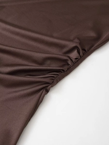 Detailed close-up of ruched side design on a dark brown long sleeve crew neck T-shirt