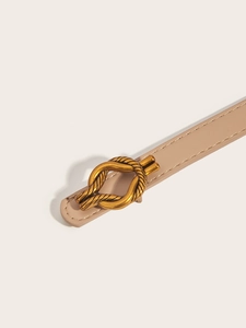 Detailed close-up of a beige leather belt featuring a golden twisted rope metal buckle