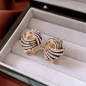 Vintage gold wing earrings with cross design and sparkling crystals in a velvet jewelry box