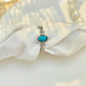Vintage stainless steel open ring with turquoise stone on white silk background