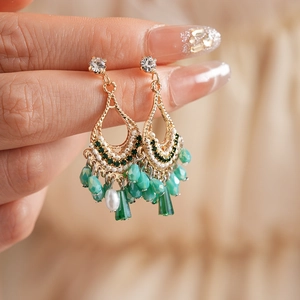 Close-up of bohemian gold tassel earrings with intricate beads and sparkling crystals