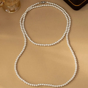 Elegant double-layered long pearl necklace with white round pearls on khaki background