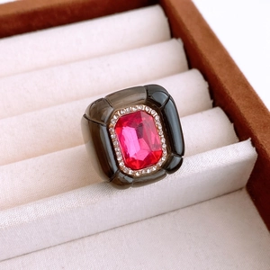 Macro detail of a vintage resin ring featuring a pink emerald-cut stone and diamond halo