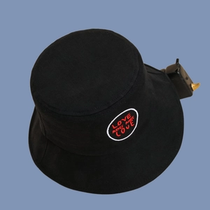 Detail of black canvas bucket hat with red LOVE MAKES MORE LOVE circular embroidery