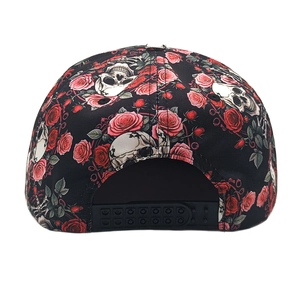 Detail view of the black snapback hat featuring a floral skull print and plastic strap