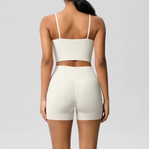 Rear view of cream yoga set showing thin strap sports bra and high-waisted gym shorts