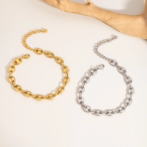 Gold and silver pig nose chain anklets with lobster clasp on a minimalist background