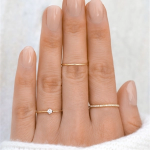 Detailed view of three-piece gold ring set featuring zircon accents in a stacked style