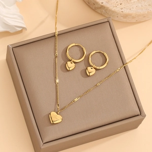 Golden heart-shaped jewelry set with necklace and earrings displayed on a brown box