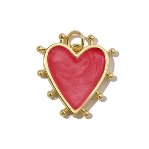 Macro detail of red glitter heart pendant with gold plated metal frame and top ring