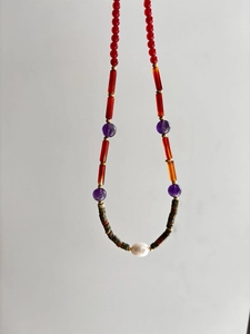 Detail of bohemian necklace with colorful beads, metal spacers and baroque pearl