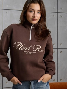 Détail de la demi-fermeture éclair et de l'imprimé lettres sur le sweat-shirt marron