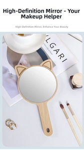 Close-up of cat-ear wooden hand mirror with clear reflection and hanging hole handle