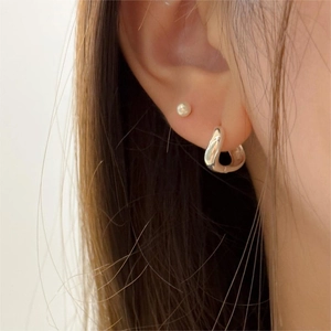 Vue macro de créoles irrégulières en argent 925 et boucles d'oreilles perles