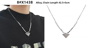 Macro detail of silver snake chain necklace with engraved triangle pendant