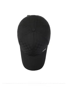 Top-down macro view of black baseball cap with checkerboard texture and metal emblem