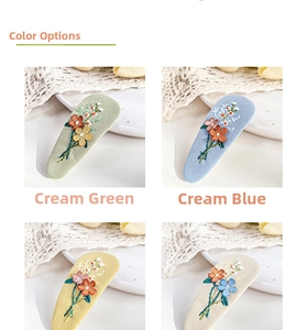 Close-up of embroidered floral BB clips in various pastel colors on corduroy fabric