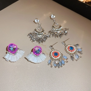 Detail of crystal fringe, purple stone and ethnic beaded tassel earrings set