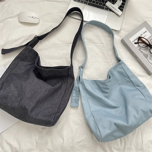 Detail of canvas tote bags with adjustable metal buckles and dense fabric texture