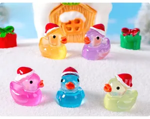Set of five colorful resin ducks wearing Santa hats on a snowy miniature scene
