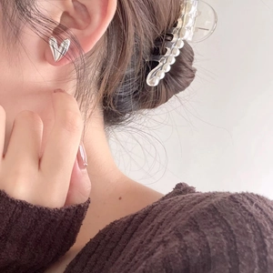 Minimalist 925 sterling silver 3D heart stud earrings worn by a female model