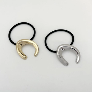 Detail of high-elasticity black hair ties with minimalist gold and silver U-shaped metal buckles