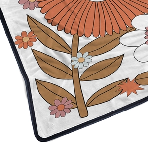Retro 70s floral flannel blanket with orange flowers and soft fleece texture