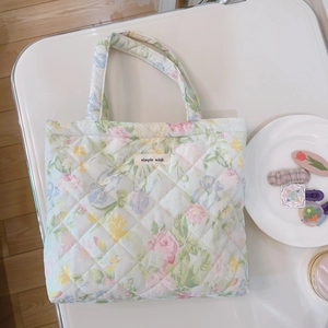 Close-up of diamond-quilted floral handbag fabric with small flowers and simple wish label