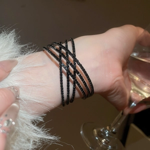 Gros plan d'un bracelet croisé double couche serti de zircons noirs dans un décor chic