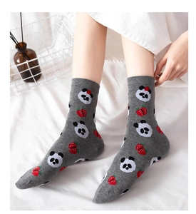 Close-up of grey mid-calf socks with cute panda and strawberry patterns on white bedding