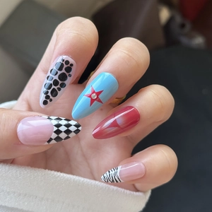 Detailed view of long almond press-on nails with leopard, star, and checkerboard patterns
