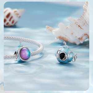 Macro detail of S925 silver submarine charm with rainbow window on a mesh bracelet