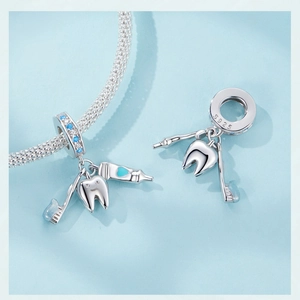 Macro detail of S925 sterling silver toothbrush and toothpaste pendant with blue enamel