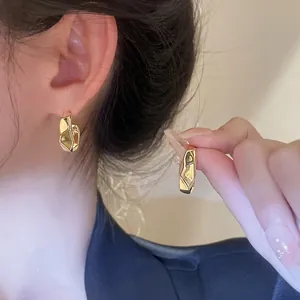 Minimalist gold plated irregular geometric C-shaped stud earrings on female ear