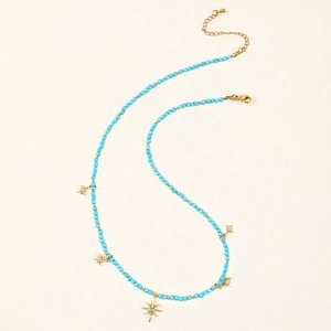 Detail of blue faceted beads and gold starburst pendants on an adjustable necklace