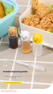 Close-up of portable sauce bottles with cute cat lids and a plastic transfer pipette