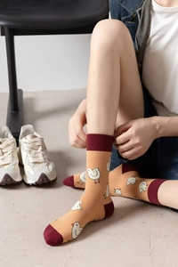 Detail of yellow cotton socks with red trim and white chick pattern on model feet