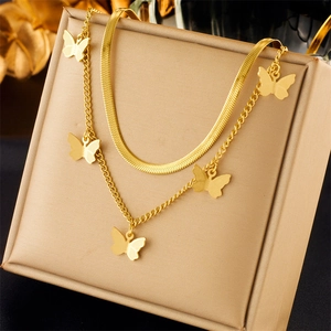 Detail of a double-layered gold snake chain necklace featuring five butterfly charms