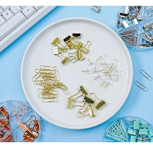 Flat lay of macaron color binder clips, paper clips, and push pins in a round dish
