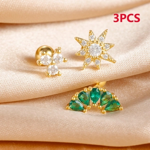 Macro detail of 3pcs gold stainless steel stud earrings with zircon on silk fabric