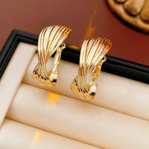 Detailed view of twisted golden hoop earrings displayed in a black jewelry gift box
