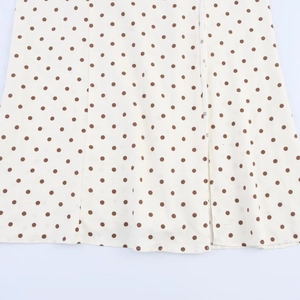 Detail of polka dot midi dress showing cream fabric with brown dots and button placket