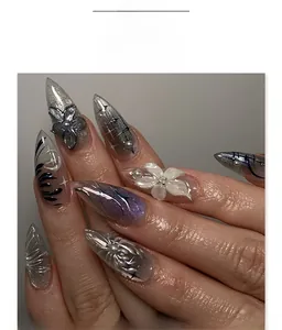 Macro detail of Stiletto press-on nails with 3D floral accents and purple cat-eye effect