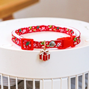 Detail of red Christmas pet collar with gift charm and holiday pattern for cats and dogs